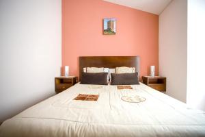 1 dormitorio con 1 cama grande y paredes de color naranja en 2 bedrooms house with city view shared pool and enclosed garden at Sortelha, en Sortelha