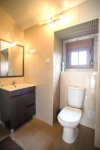 y baño con aseo, lavabo y espejo. en 2 bedrooms house with city view shared pool and enclosed garden at Sortelha, en Sortelha