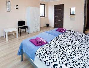 - une chambre avec un lit noir et blanc et une chaise dans l'établissement Moody Hostel, à Mława