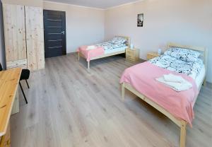 - une chambre avec 2 lits et du parquet dans l'établissement Moody Hostel, à Mława