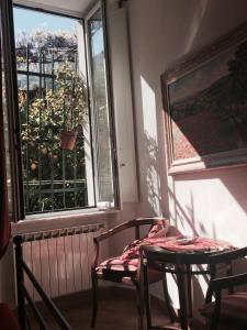 um quarto com uma cadeira, uma mesa e uma janela em La Dolce Vita em Levanto