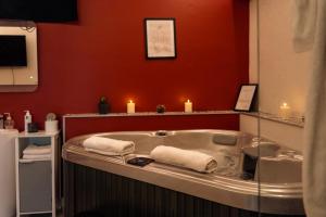 a bathroom with a bath tub with candles in it at Ignite Love Room in Nantes