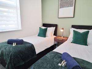 ワトフォードにあるBright 3 Bed Apartment With Terrace, Free Parking!の緑と白の部屋のベッド2台