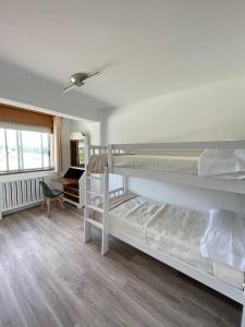 - une chambre avec 2 lits superposés et un bureau dans l'établissement Milladoiro, à Teo