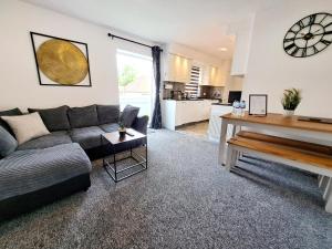 ein Wohnzimmer mit einem Sofa und einem Tisch in der Unterkunft Bright 3 Bed Apartment With Terrace, Free Parking! in Watford