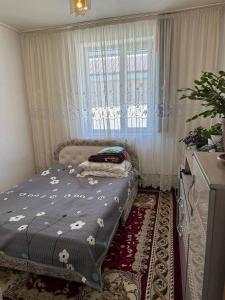 um quarto com uma cama e uma janela em Green guest house em Bokonbayevo