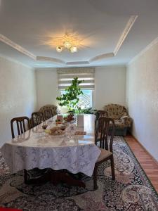 a dining room with a table with a plant on it at Green guest house in Bokonbayevo
