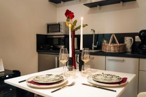 a table with plates and glasses and a vase with a rose at Ignite Love Room in Nantes