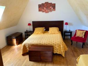 SalviacにあるMaison de 2 chambres avec piscine privee jardin amenage et wifi a Salviacのベッドルーム1室(ベッド1台、赤い椅子付)