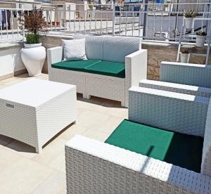 a group of wicker chairs and tables on a balcony at Tulipano Bianco in Ostuni