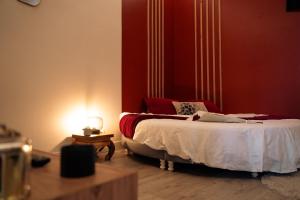 1 dormitorio con 1 cama con pared roja en Ignite Love Room, en Nantes