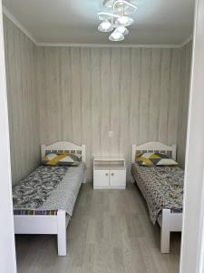 Duas camas sentadas uma ao lado da outra num quarto em Green guest house em Bokonbayevo