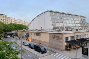 a large building with cars parked in a parking lot at Hotel da Música in Porto