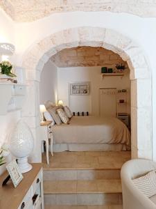 オストゥーニにあるTulipano Biancoのアーチ道のある部屋で、ベッドルーム1室(ベッド1台付)