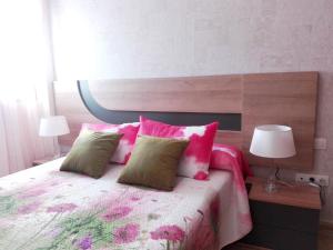 sypialnia z łóżkiem z różowymi i zielonymi poduszkami w obiekcie One bedroom apartement at La Restinga Isla del Hierro 200 m away from the beach with wifi w mieście La Restinga