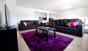 Una sala de estar con un sofá y una mesa sobre una alfombra morada. en Spacious Villa in Celorico de Basto with Private Pool, en Celorico de Basto