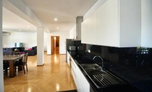 cocina con armarios blancos y comedor en Spacious Villa in Celorico de Basto with Private Pool, en Celorico de Basto