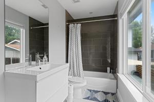 uma casa de banho com uma banheira, um lavatório e uma janela em Detached 1 Bed 1 Bath In-law Suite 3 miles from Downtown! em Austin