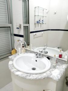 a white bathroom with a sink and a mirror at 4 bedrooms appartement at Bueu in Bueu