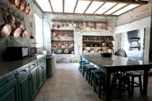 uma cozinha com uma mesa e algumas panelas e frigideiras em 6 bedrooms villa with private pool furnished garden and wifi at Santo Tirso em Santo Tirso