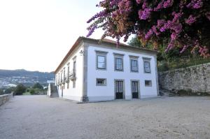 um edifício branco com uma parede e flores roxas em 6 bedrooms villa with private pool furnished garden and wifi at Santo Tirso em Santo Tirso