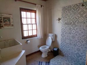 uma casa de banho com um WC, uma banheira e uma janela. em Fairfield Cottages em Ceres