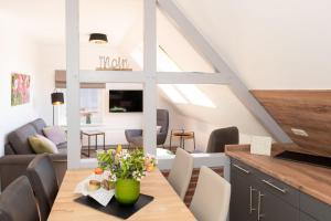 una cocina y una sala de estar con una mesa con flores. en Bauernhaus Wohnung 1, en Bojendorf