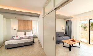 ゲオルギオポリスにあるSunlight Beach Hotelのベッドルーム1室(ベッド1台、ソファ、テーブル付)