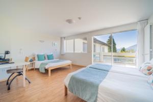 a bedroom with two beds and a desk and a window at Centre Jean XXIII in Annecy +37 photos