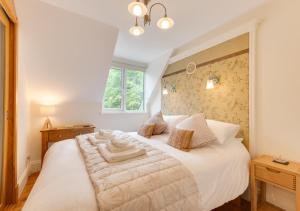 a bedroom with a large white bed in a room at Wisteria Cottage in Parkham