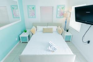 a living room with a white couch and a flat screen tv at Cabanas of Treasure Island in St. Pete Beach