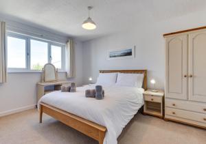 a bedroom with a large white bed and a window at Withyside in Croyde