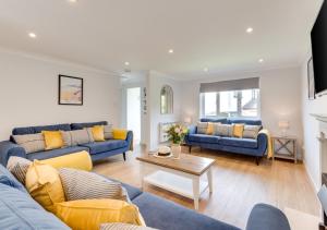 a living room with two blue couches and a table at Withyside in Croyde