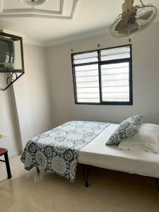 a bedroom with a bed and a tv in it at Hotel Central Johanna in Tuluá