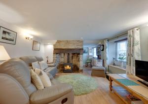 un soggiorno con divano e camino di Wisteria Cottage a Great Torrington