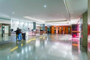 a man standing in a lobby with his luggage at Apart Hotel Centro de Brasília (Garvey Park Hotel) in Brasilia +16 photos