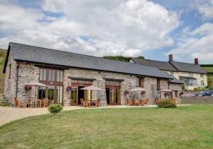 a stone house with tables and chairs in front of it at Workshop in Bampton