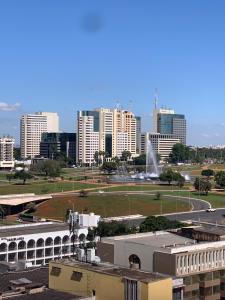 a view of a city with tall buildings and a fountain at Apart Hotel Centro de Brasília (Garvey Park Hotel) in Brasilia