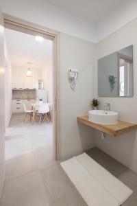 a white bathroom with a sink and a dining room at Casa Campos Arillas in Arillas