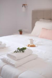 - une pile de serviettes sur un lit avec une tasse de café dans l'établissement Casa Campos Arillas, à Arillas