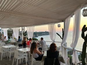 un gruppo di persone seduti ai tavoli in un ristorante di Mediterranean Boutique Hotel a Tropea