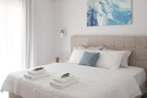 a white bed with two white towels on it at Casa Campos Arillas in Arillas