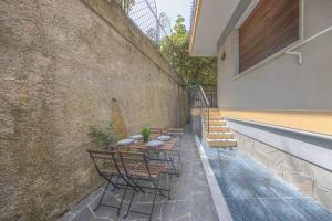 a patio with tables and chairs next to a wall at RAPALLO APARTMENT Comodo e in Ottima Posizione in Rapallo