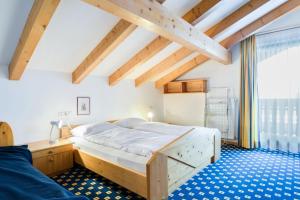 a bedroom with a bed and a large window at Apparthotel Feldhof - Living and Bistro in Nova Ponente
