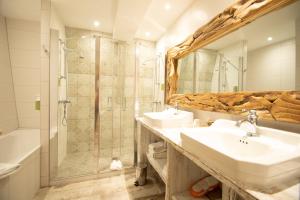 a bathroom with two sinks and a shower at Hotel Beaucour in Strasbourg +141 photos