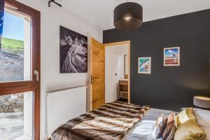 1 dormitorio con cama y ventana en La Suite Édelweiss - Welkeys, en Combloux