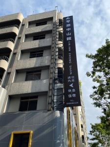 a tall building with a sign in front of it at 苓旅中山館-Lininn ZhongShan in Taipei