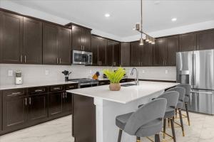 uma cozinha com armários de madeira e um balcão branco em 6 Bedrooms 5 Bathrooms Storey Lake 4370 Rs em Kissimmee