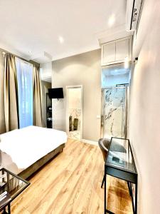 a bedroom with a bed and a glass table at AD Suites Nazionale in Rome