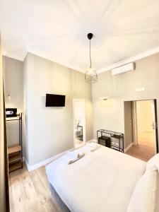a bedroom with a white bed and a tv on the wall at AD Suites Nazionale in Rome